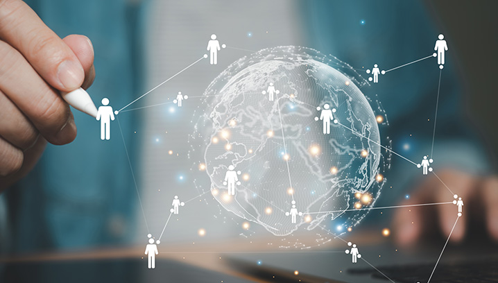 Hand, die mit einem Stift eine digitale Welt mit verbundenen Menschen darstellt, vermittelt Innovation und Vernetzung.